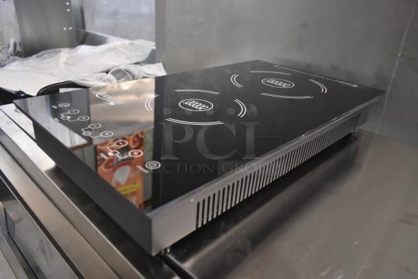 Portable induction cooktop with black glass surface, three burners, digital controls, and brand logo. New condition.