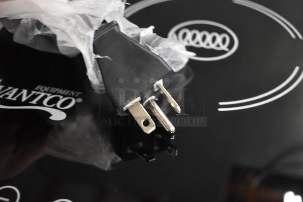 Avantco Equipment plug on a sleek black surface. Plug shows two flat and one round prong.