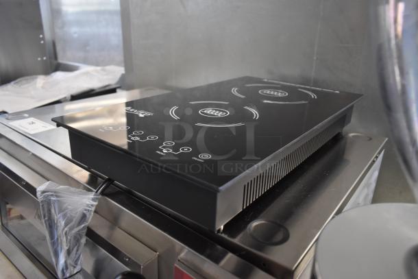 Double burner induction cooktop with digital controls, sleek black surface, model label visible. Excellent condition.