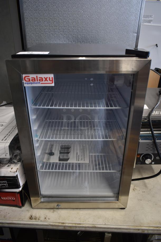 Galaxy Equipment countertop display fridge with stainless steel frame, glass door, three adjustable shelves, and visible power cord.