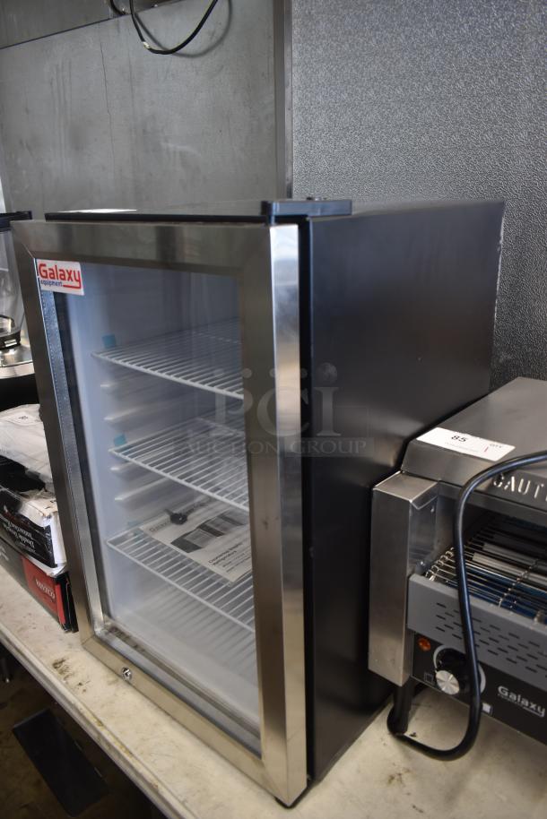 Galaxy countertop refrigeration unit with glass door, four wire shelves, and stainless steel trim, in good condition.