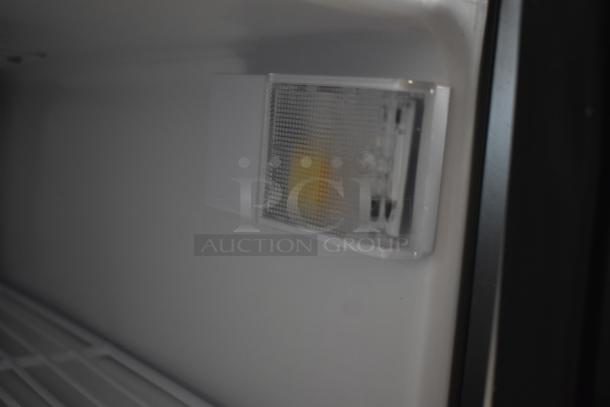 Close-up of an interior appliance light fixture inside a refrigerator, featuring a textured cover and visible bulb. Good condition.