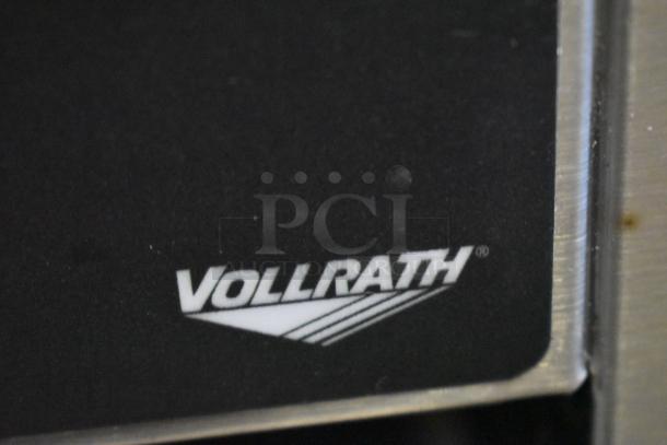 Vollrath appliance with logo visible on black panel, stainless steel edge, indicating quality kitchen equipment.