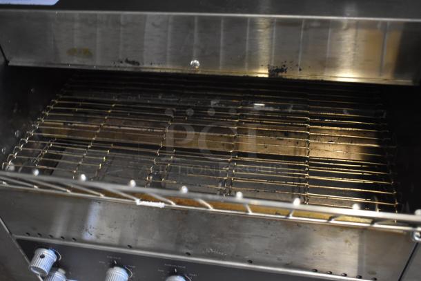 Commercial toaster oven, stainless steel, dual control knobs, interior wire rack, visible wear and signs of use.