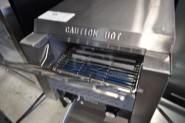 Stainless steel commercial toaster with grill rack, labeled "CAUTION HOT." Appears in good condition.