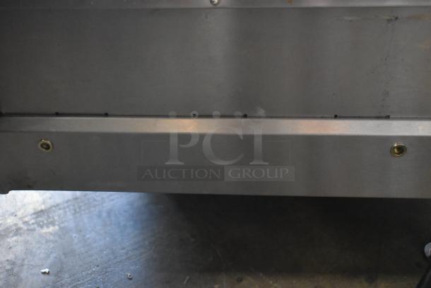 Stainless steel panel with bolts, showing wear marks. Industrial use, suitable for heavy-duty applications. No labels visible.