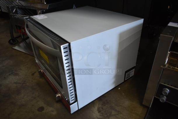 Commercial convection oven with a glass door, silver handles, and control knobs. In good condition with minor scratches. QR code label on the side.