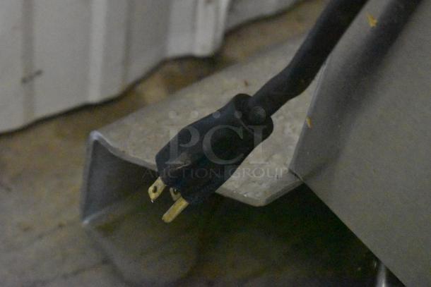 Black electrical power cord with two-prong plug, minor wear, suitable for appliances.