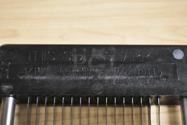 Black blade sharpener with metal wires, labeled "THIS SIDE SHARP 3/16 CUT 5MM P/N 15115," in used condition.