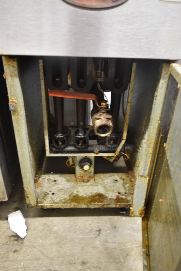Commercial stove broiler grill section, metal construction, visible signs of rust and wear, missing components.