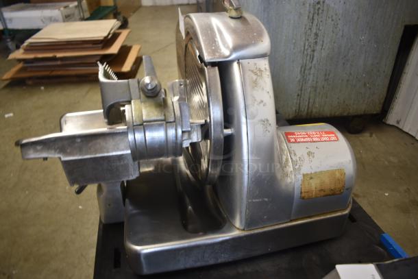 Vintage meat slicer with stainless steel body, visible signs of wear, and East Coast Food Equipment label; industrial use.