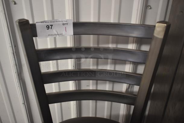 Metal chair with ladder back design, tag displaying "97" from PCI Auctions. Sturdy condition, steel frame, minimal wear.