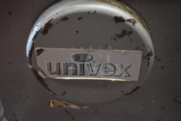 Univex metal appliance with rust and wear, featuring a prominent Univex logo. Condition shows significant aging.