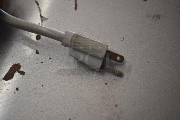 Worn two-prong electrical plug with white cable, visible dirt on both plug and cable; needs cleaning or replacement.