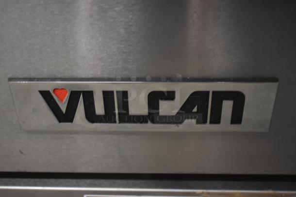 Vulcan commercial kitchen appliance logo on stainless steel surface. Features red heart detail. Tag indicates brand.