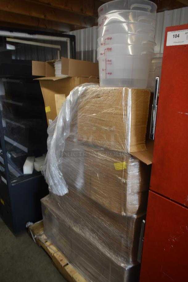 Stack of large cardboard boxes wrapped in plastic on a pallet, with clear measuring containers labeled in quarts on top.