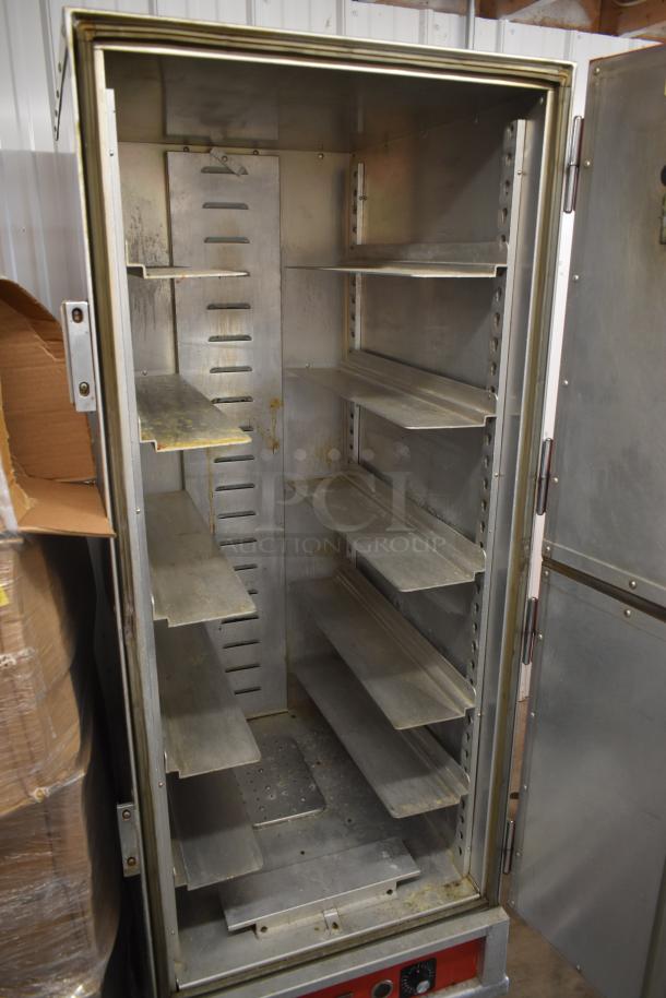 Commercial stainless steel warming cabinet, multiple shelves, used condition with visible wear, ideal for food service.