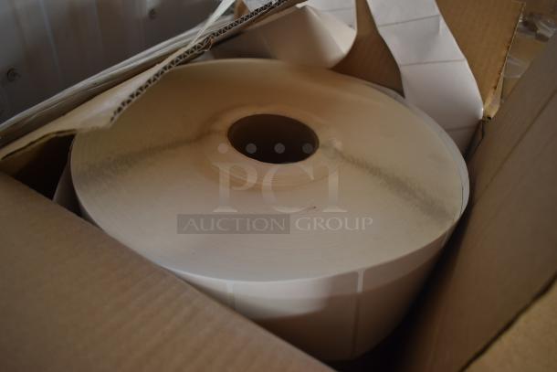 Large roll of adhesive labels in a cardboard box. Labels appear unused and in good condition.