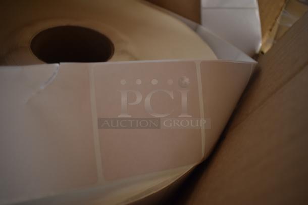 Large roll of blank adhesive labels in a cardboard box, unmarked and in new condition, ideal for printing or organization.