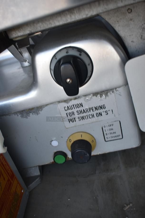 Commercial slicer control panel showing a knob with settings from 0 to S, and caution sign for sharpening.