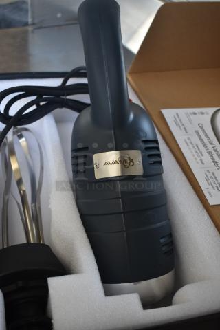 Avamix commercial immersion blender, new condition, black with metal label, power cord included, packaged in foam casing.