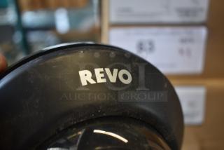 Close-up of a black camera lens with "REVO" branding, showing slight wear. Suitable for videography, emphasizing lens quality.