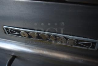 Vintage metal appliance with "Attias" label, showing wear and rust, indicating age and use.