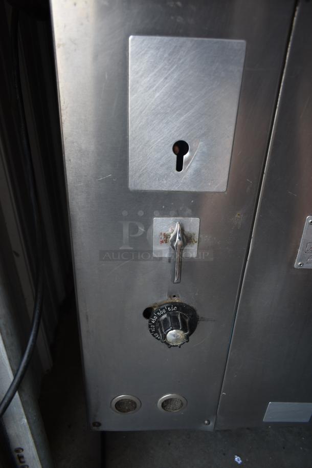 Stainless steel commercial oven with adjustable temperature knob, visible keyhole, and control lever. In used condition.