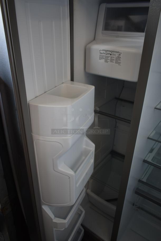 Stainless steel refrigerator interior with ice maker, adjustable glass shelves, and door bins; clean and well-maintained.