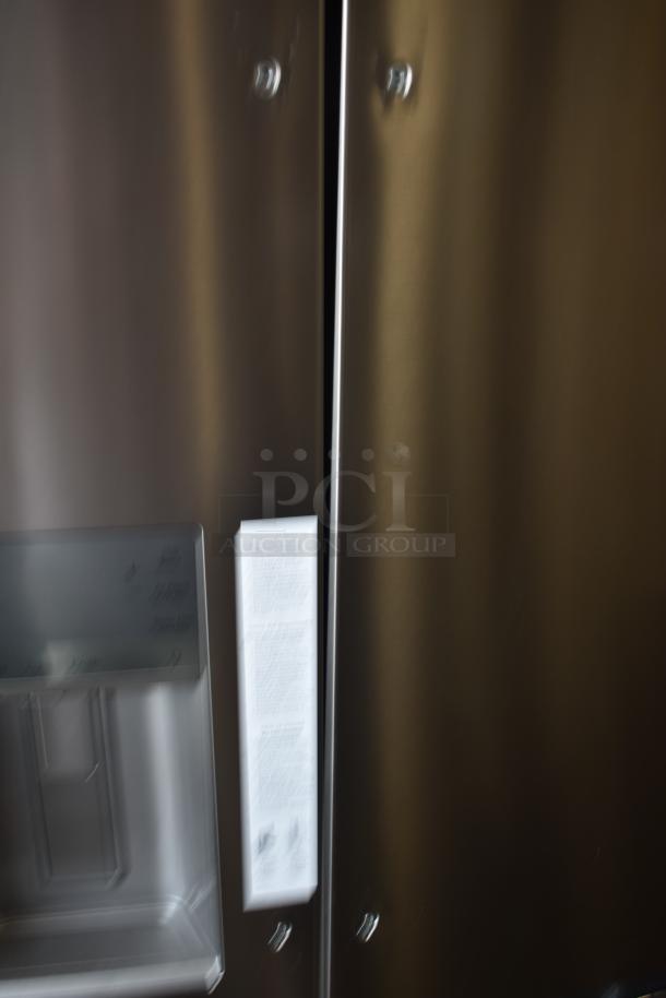 Stainless steel refrigerator with water dispenser, visible instruction label on door, modern design, excellent condition.