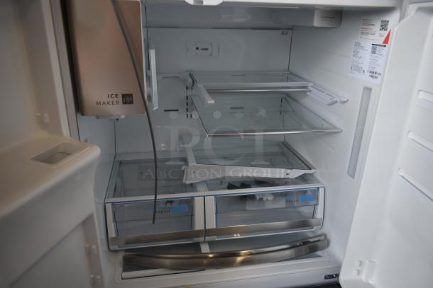 Stainless steel refrigerator interior with ice maker, adjustable glass shelves, and crisp drawers. Pristine condition.