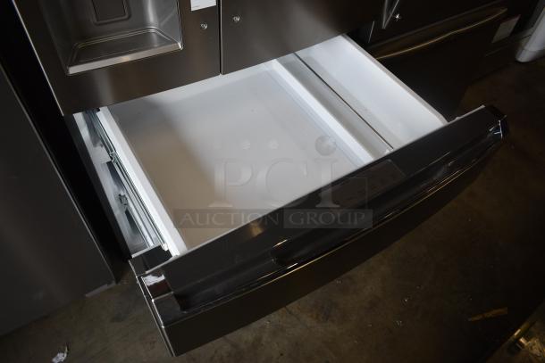 Stainless steel refrigerator with open freezer drawer, showcasing a clean and spacious interior. Modern design, excellent condition.