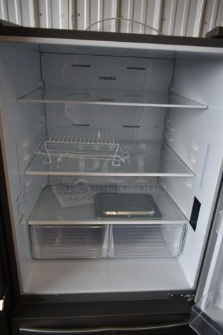Mora stainless steel refrigerator interior with adjustable shelves, wire rack, and two transparent drawers. Appears unused.