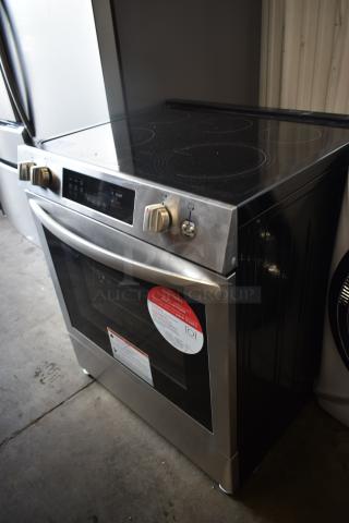 Stainless steel Frigidaire electric range with digital controls and smooth cooktop. Features energy rating labels.