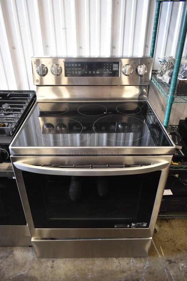Stainless steel electric range with glass cooktop, control knobs, digital display, and spacious oven in excellent condition.