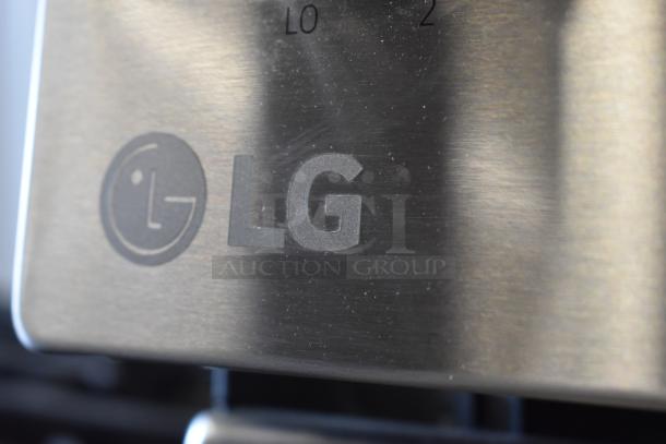 Close-up of an LG stainless steel appliance faceplate with logo and numeric control markings. Good condition, minimal wear.