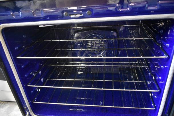 Blue oven interior with two chrome racks, fan at back, and clean condition. Suitable for modern kitchens.