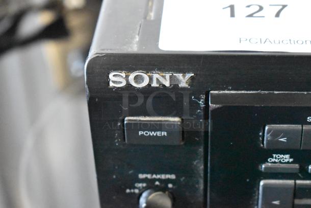 Close-up of a vintage Sony audio component with visible power button. Signs of wear, and auction tag number 127 shown.
