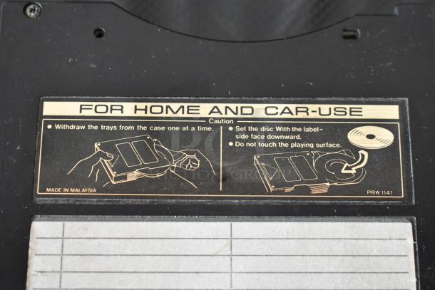 Close-up of a vintage disc changer instructions label for home and car use. Made in Malaysia. Instructions for handling included.