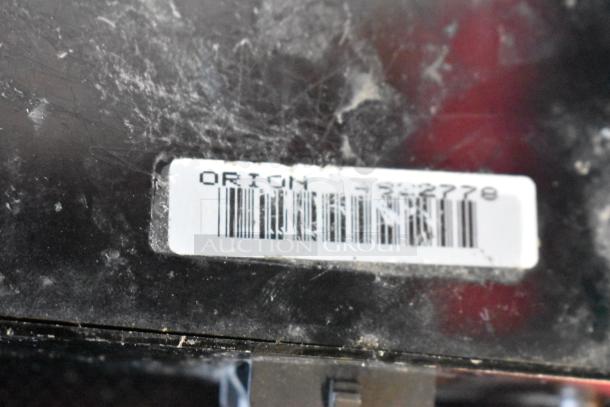 Close-up of a scratched and dusty surface with a barcode label reading "ORION" and numbers, indicating identification.