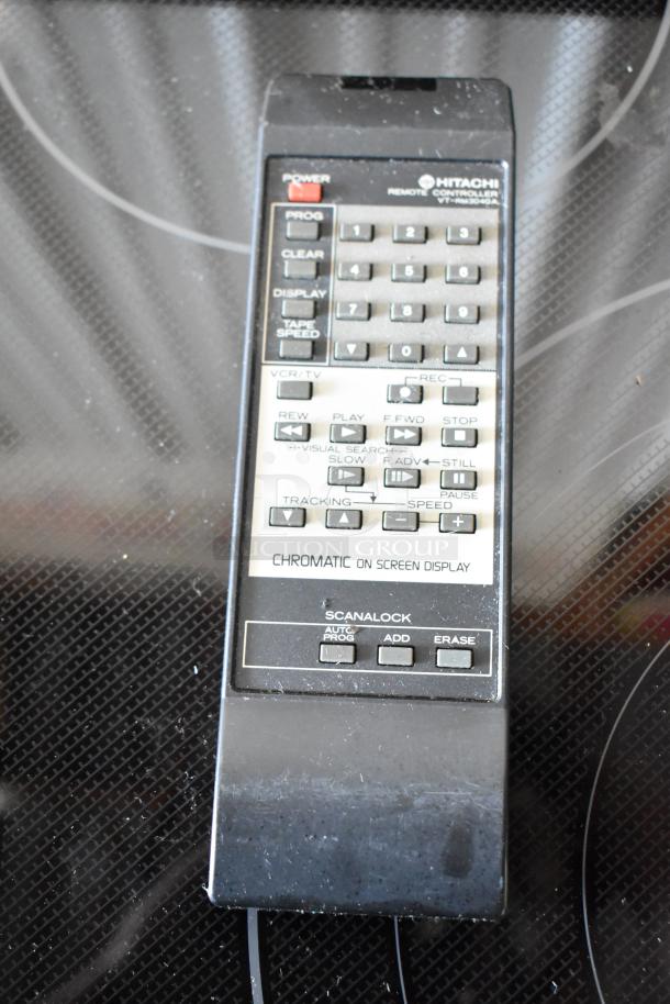 Hitachi remote controller VT-RM3040A with chromatic display, buttons for VCR functions, light wear, key features labeled.