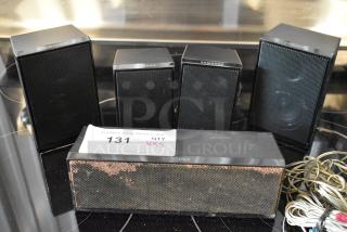 Five Samsung speakers, black, with visible wear on the front mesh. Includes assorted cables. Auction lot tag reads "131 QTY VX5".