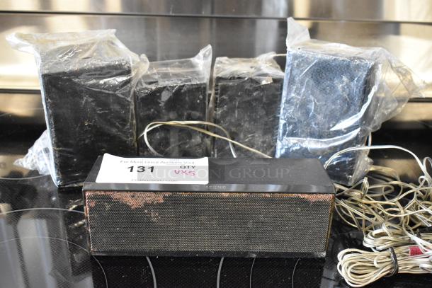 Set of Samsung speakers, wrapped in plastic, showing wear. Includes cords. Auction label reads "131, QTY VXS."