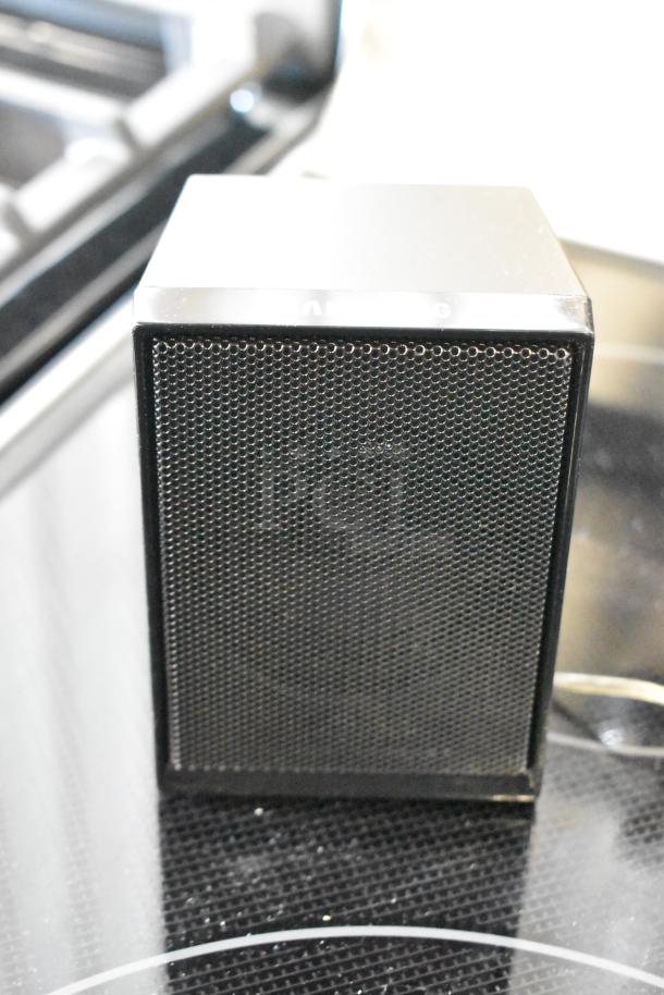 Black metal speaker with perforated front, in good condition. Markings indicate "AB" and "6" on top edge.
