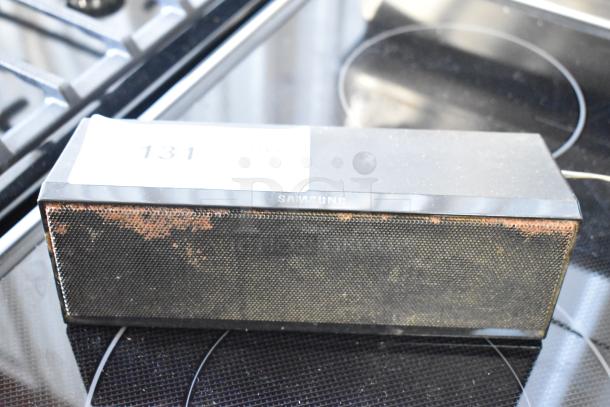 Samsung wireless speaker with visible rust on the mesh grille, marked with lot number 131 on top. Used condition.