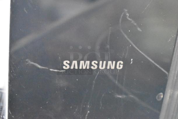 Samsung electronic device showing surface scratches and wear, brand logo visible in white lettering.