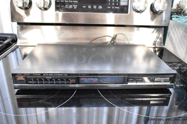 Vintage Fisher AM/FM stereo synthesizer tuner, model FM-671, with digital display and function buttons, in used condition.