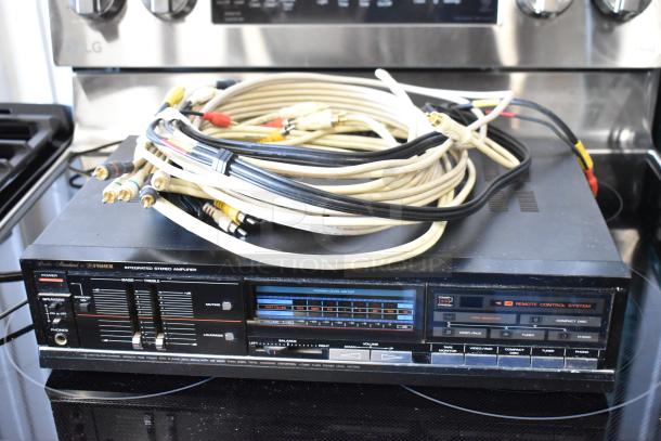Vintage Fisher stereo amplifier with integrated controls and power level meter. Includes various audio cables. Good condition.