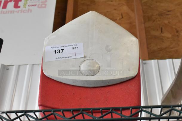 Red and white cooler with a triangular lid, visible wear. Auction tag "137" indicates PCI Auctions listing.
