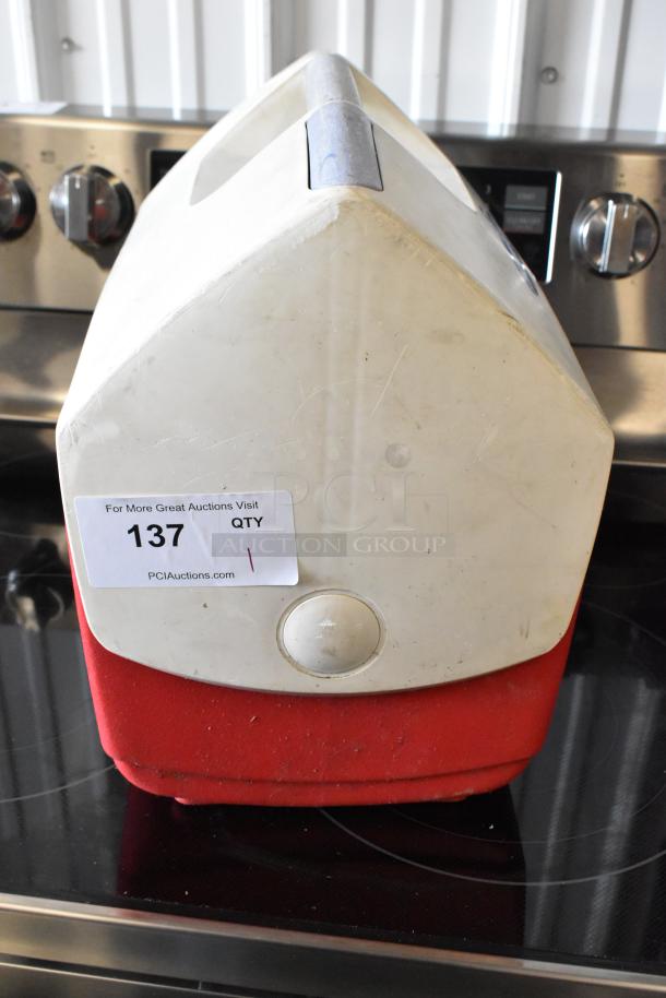 Red and white vintage cooler with handle, scuffed surface, auction tag "137", PCI Auctions label visible.